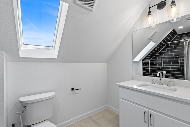 bathroom featuring walk in shower, toilet, vaulted ceiling with skylight, vanity, and hardwood / wood-style flooring