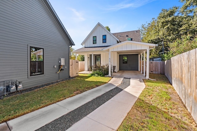 modern inspired farmhouse featuring a carport and a front yard