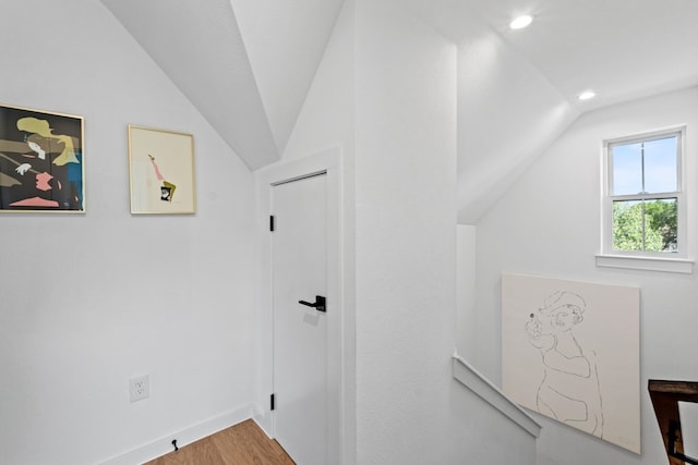 corridor featuring wood-type flooring and lofted ceiling