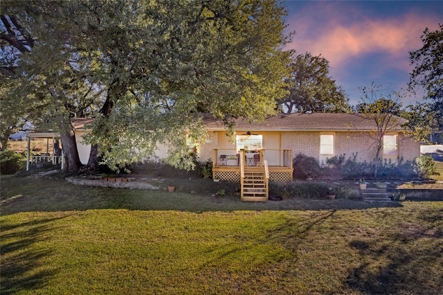 back house at dusk featuring a yard and a wooden deck