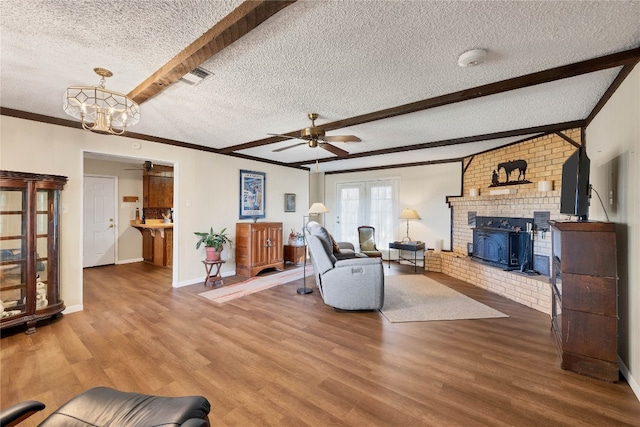 living room with beam ceiling, hardwood / wood-style floors, ceiling fan with notable chandelier, and a textured ceiling