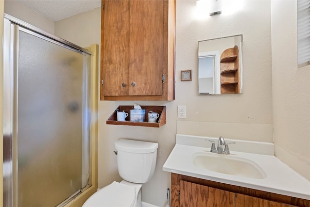 bathroom featuring toilet, vanity, a textured ceiling, and walk in shower