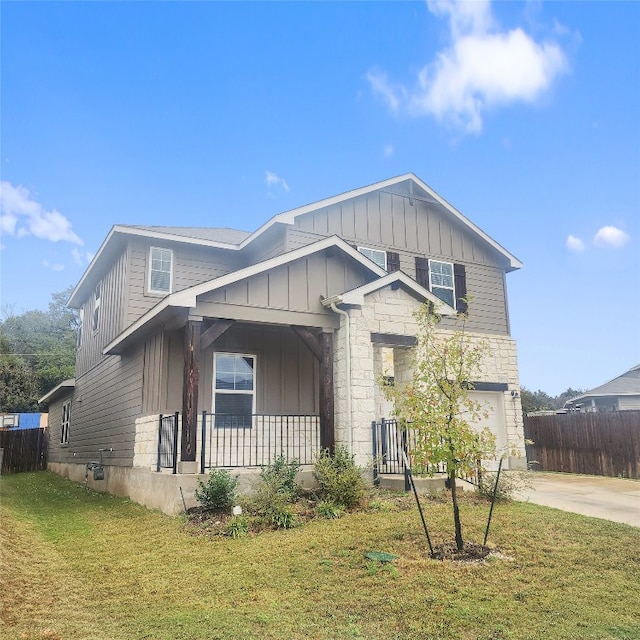 view of front of house featuring a front yard, a porch, and a garage