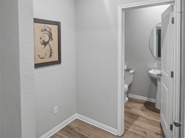 bathroom with toilet and wood-type flooring