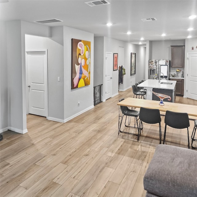 dining room with light wood-type flooring and sink