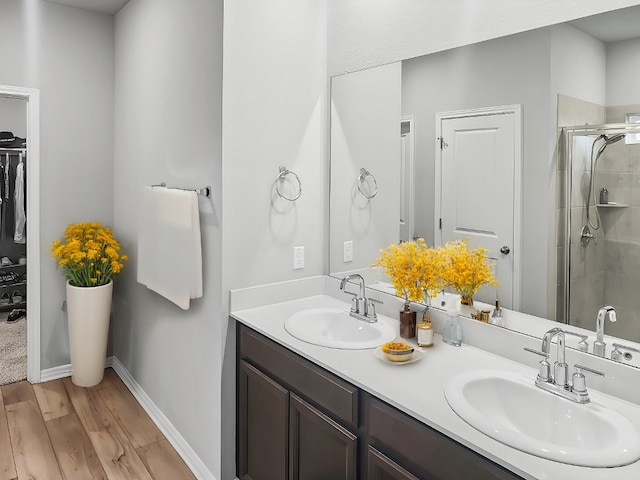 bathroom featuring hardwood / wood-style flooring, vanity, and an enclosed shower