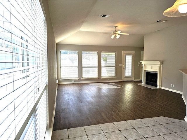 unfurnished living room featuring ceiling fan, wood-type flooring, and lofted ceiling