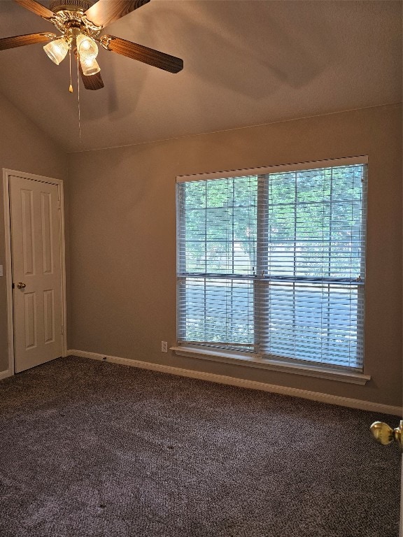 carpeted empty room featuring a wealth of natural light, ceiling fan, and lofted ceiling