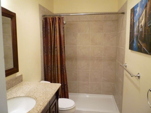 bathroom with a shower with shower curtain, vanity, and toilet