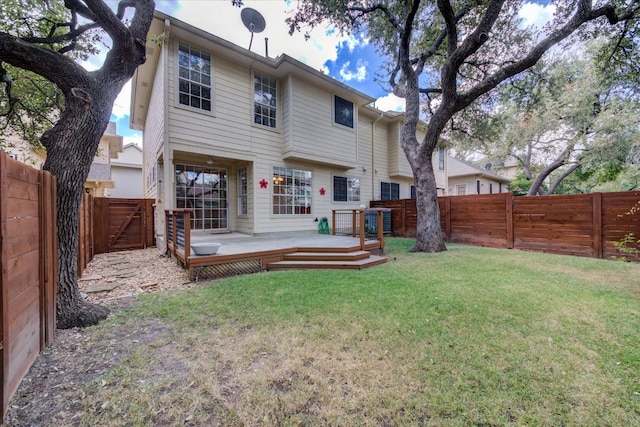 rear view of property with a lawn and a wooden deck