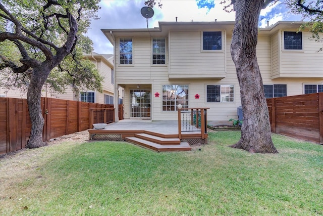 rear view of house with a deck and a lawn