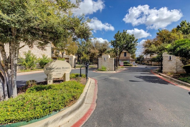 11000 Anderson Mill Rd Unit 9, Austin, TX 78750 - view of asphalt road with a gate, curbs, and a gated entry