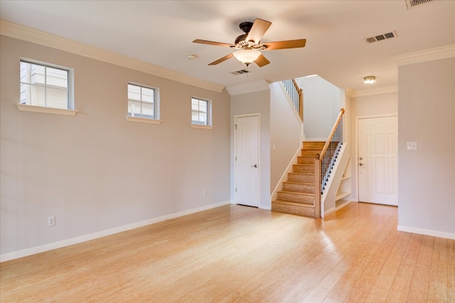 empty room with ceiling fan, a healthy amount of sunlight, light hardwood / wood-style floors, and crown molding