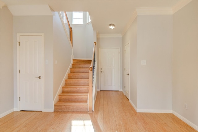 stairs featuring crown molding and hardwood / wood-style flooring