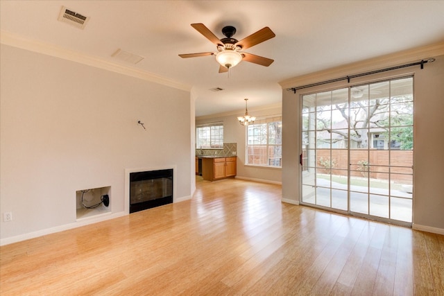 unfurnished living room featuring crown molding, light hardwood / wood-style flooring, and ceiling fan with notable chandelier