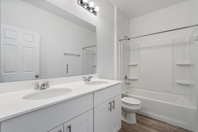 full bathroom with shower / bathing tub combination, hardwood / wood-style floors, vanity, and toilet