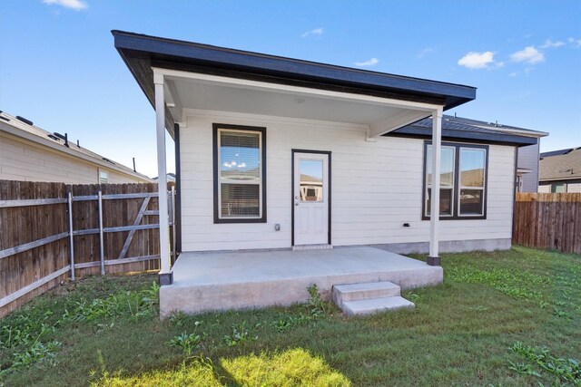 back of property featuring a lawn and a porch