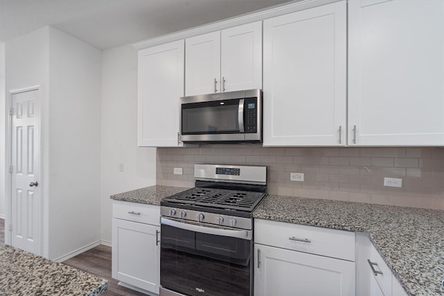 kitchen with white cabinetry, light stone countertops, tasteful backsplash, dark hardwood / wood-style floors, and appliances with stainless steel finishes