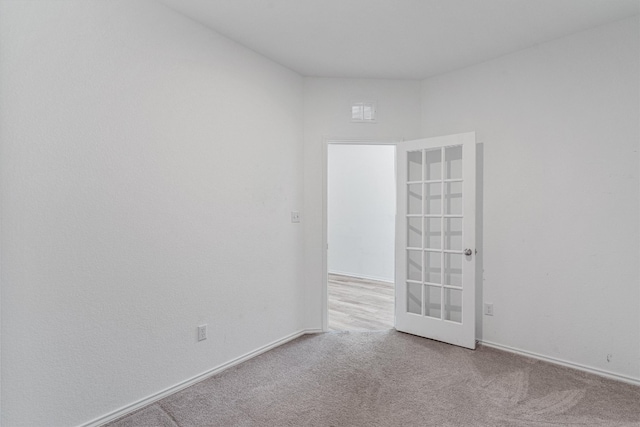 unfurnished room featuring french doors and carpet floors