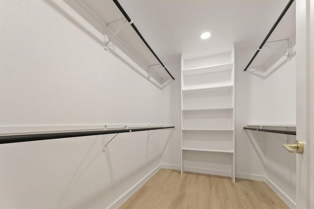 walk in closet with light hardwood / wood-style floors