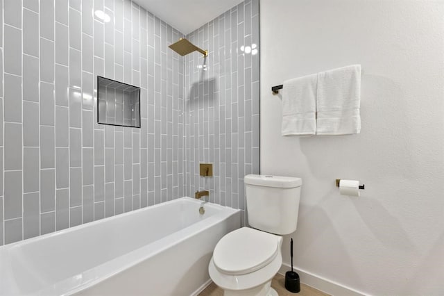 bathroom featuring tiled shower / bath combo and toilet