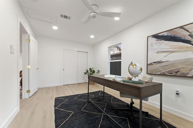 home office with light hardwood / wood-style floors and ceiling fan