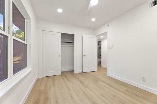 unfurnished bedroom featuring ceiling fan, light wood-type flooring, and a closet