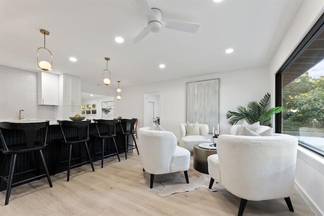 living room with light wood-type flooring and ceiling fan