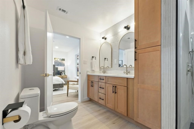 bathroom with tasteful backsplash, toilet, vanity, and hardwood / wood-style flooring