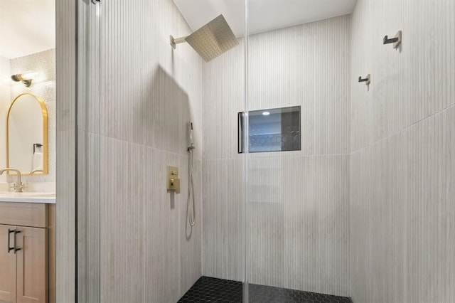 bathroom featuring a tile shower and vanity