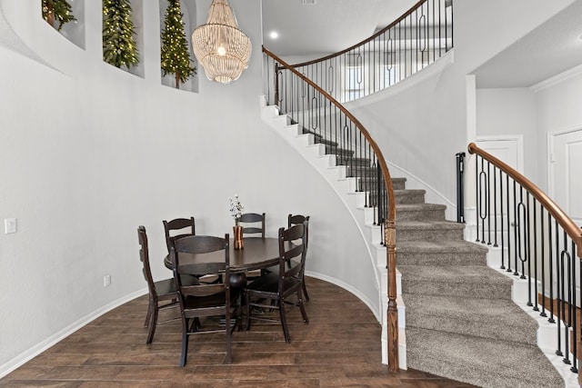 dining room with crown molding, dark hardwood / wood-style floors, and an inviting chandelier