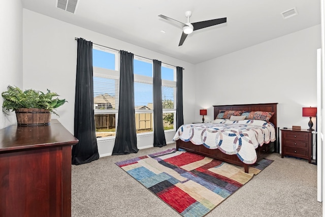 bedroom featuring ceiling fan, a water view, and light carpet