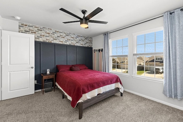 bedroom with carpet floors, ceiling fan, and brick wall