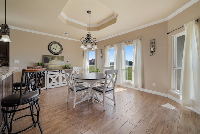 dining room featuring light hardwood / wood-style floors, crown molding, and an inviting chandelier