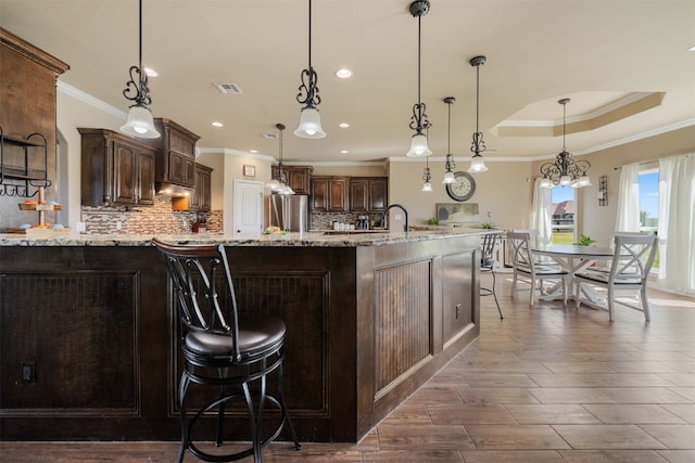 kitchen with stainless steel refrigerator, dark brown cabinetry, and hanging light fixtures