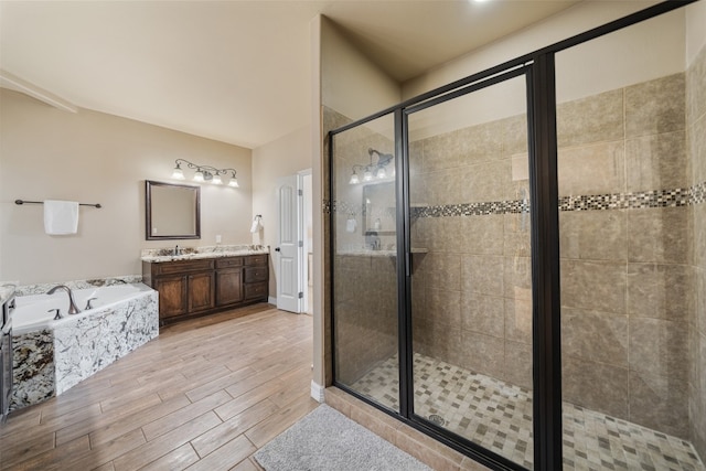 bathroom featuring plus walk in shower, wood-type flooring, and vanity