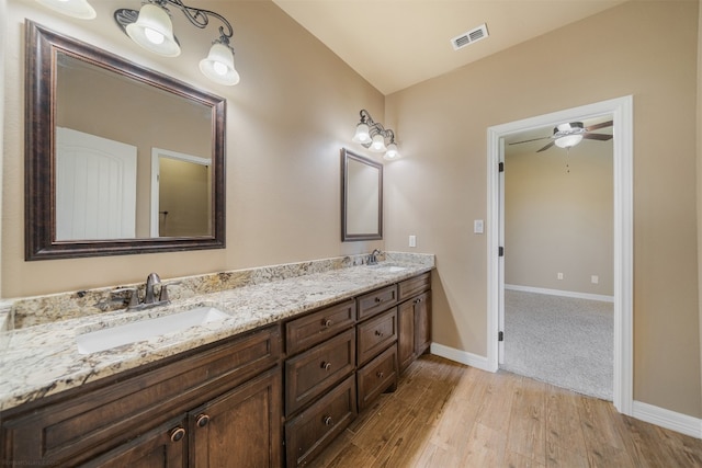 bathroom with hardwood / wood-style floors, vanity, and ceiling fan