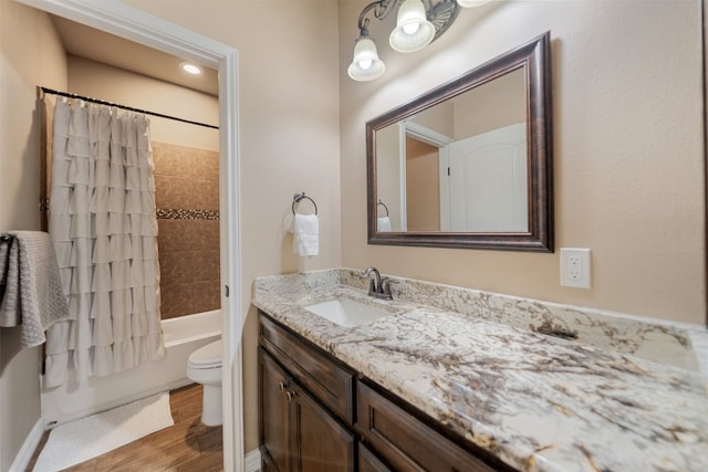 full bathroom featuring vanity, hardwood / wood-style floors, shower / bathtub combination with curtain, and toilet