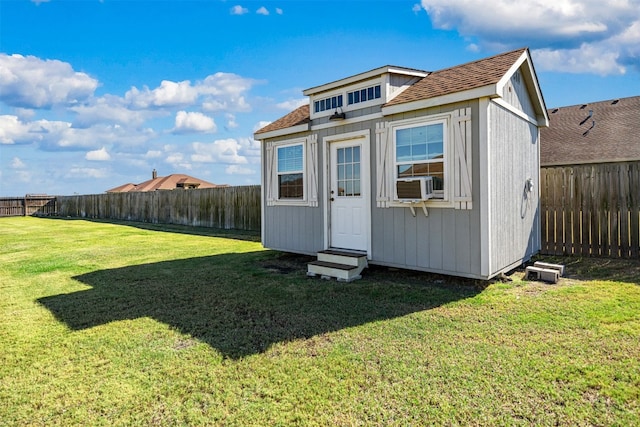 view of outdoor structure with cooling unit and a yard