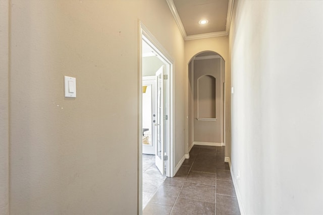 hallway with ornamental molding and dark tile patterned flooring