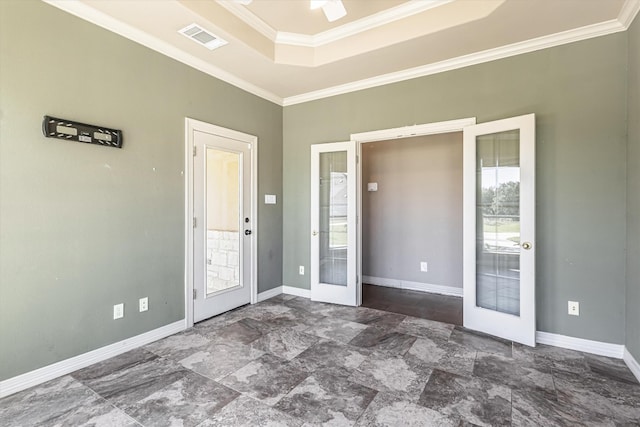 spare room with a raised ceiling, ornamental molding, ceiling fan, and french doors