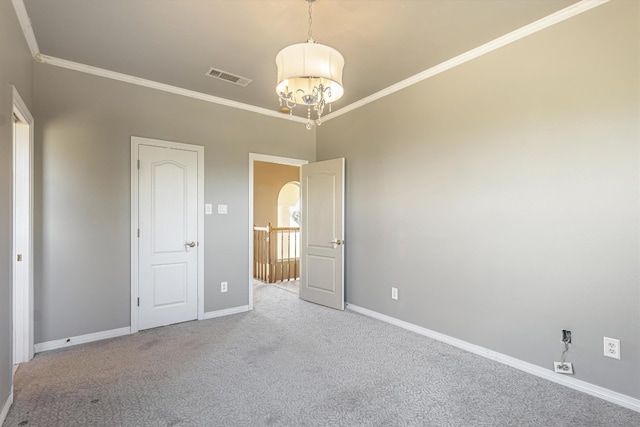 unfurnished bedroom featuring an inviting chandelier, ornamental molding, and carpet