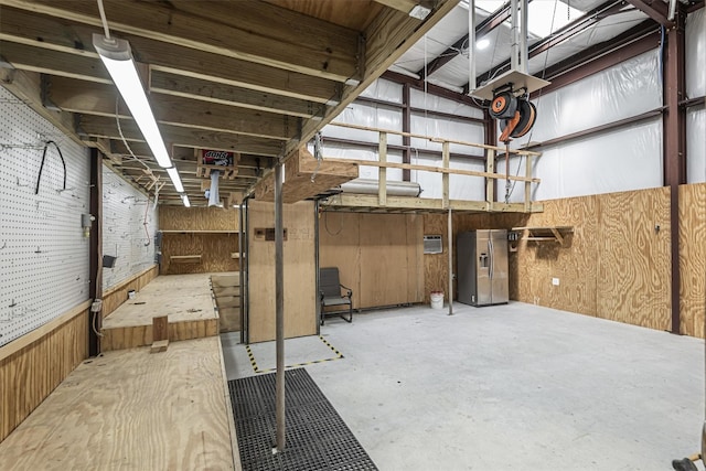 interior space featuring stainless steel fridge and wood walls