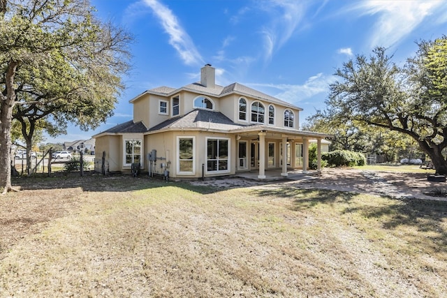 back of property with a patio area and a lawn