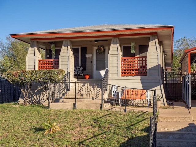 bungalow with covered porch, ceiling fan, and a front yard