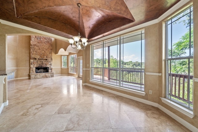 unfurnished living room with a fireplace, a chandelier, and lofted ceiling