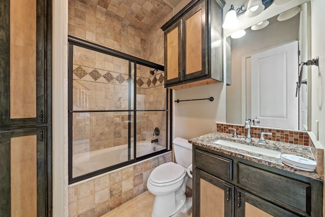 full bathroom featuring decorative backsplash, tile patterned floors, bath / shower combo with glass door, vanity, and toilet