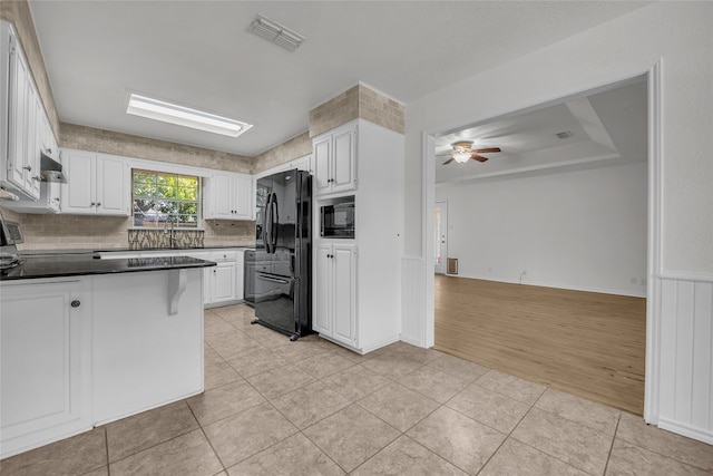 kitchen with decorative backsplash, ceiling fan, black appliances, light hardwood / wood-style flooring, and white cabinets