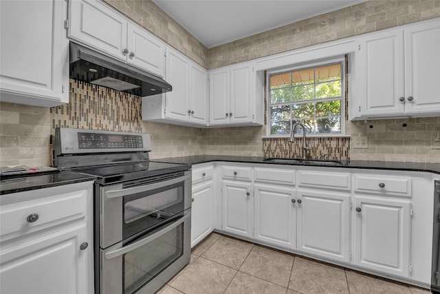 kitchen with white cabinets, light tile patterned flooring, electric stove, and sink