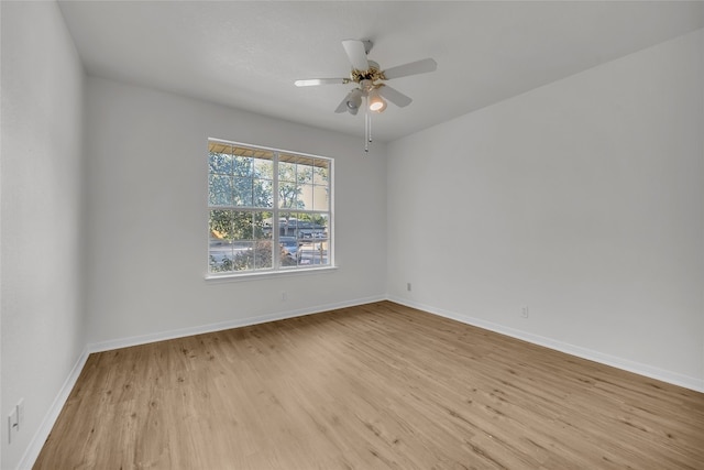 empty room with ceiling fan and light hardwood / wood-style flooring